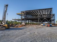 a picture of a building being built on a field near a forest in the background