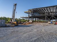 a picture of a building being built on a field near a forest in the background