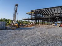 a picture of a building being built on a field near a forest in the background