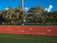 an image of a track in the middle of the day with a clock tower in the background