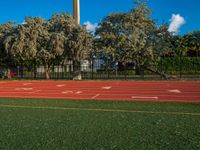 an image of a track in the middle of the day with a clock tower in the background