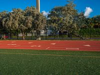 an image of a track in the middle of the day with a clock tower in the background