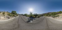 a view of a mountain road from a 360 - angle point of view lens to the sun