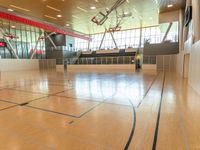 large room with high ceiling, hardwood floor, and basketball court with red walls and red trims