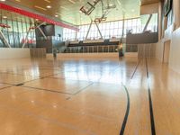 large room with high ceiling, hardwood floor, and basketball court with red walls and red trims