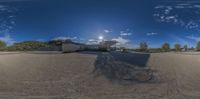 a fish eye lens view of a skate park and building in the background is a sunny day