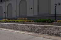 a man riding his skateboard down the road on a sidewalk near a building and grass area