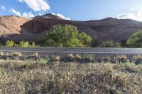 the bike is parked on a paved road through the grass and dry rocks in a canyon