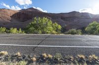 the bike is parked on a paved road through the grass and dry rocks in a canyon