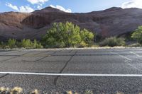 the bike is parked on a paved road through the grass and dry rocks in a canyon