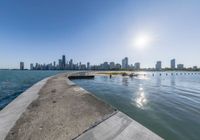 a large body of water sitting next to a city with tall buildings behind it,