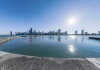 a large body of water sitting next to a city with tall buildings behind it,