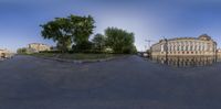 a panorama of a park bench on a sunny day in a city square with a clock tower