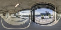 this is an 360 - view of a empty building with round windows that are reflecting a blue sky