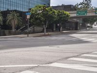 an empty city street and street signs near an intersection that looks deserted and empty on a sunny day