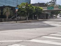 an empty city street and street signs near an intersection that looks deserted and empty on a sunny day