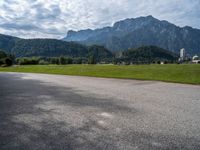 a view of an intersection with mountains in the background on a sunny day in europe