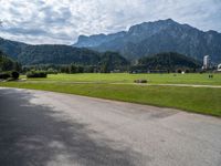 a view of an intersection with mountains in the background on a sunny day in europe