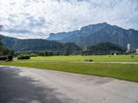 a view of an intersection with mountains in the background on a sunny day in europe