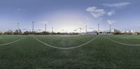 a wide angle view of a field in an outdoor setting with a sky background and clouds