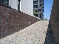 a brick wall with some buildings in the background to the left and in front a building next to it