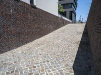 a brick wall with some buildings in the background to the left and in front a building next to it