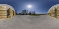 two fisheyes that are looking at stacks of wood crates behind them, and a road in the middle