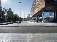 a bench at an outdoor space with many windows and benches next to it in front of the building