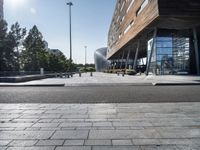 a bench at an outdoor space with many windows and benches next to it in front of the building