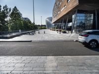 a bench at an outdoor space with many windows and benches next to it in front of the building