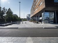 a bench at an outdoor space with many windows and benches next to it in front of the building