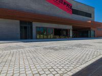 a long brick walkway and a red fire hydrant on the side of the building