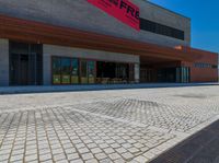 a long brick walkway and a red fire hydrant on the side of the building