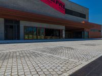 a long brick walkway and a red fire hydrant on the side of the building