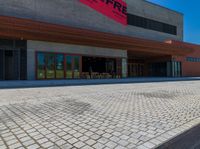 a long brick walkway and a red fire hydrant on the side of the building