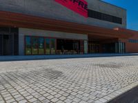 a long brick walkway and a red fire hydrant on the side of the building