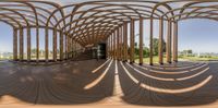 the view from inside a wooden walkway looking towards the steps and arches of a modern building