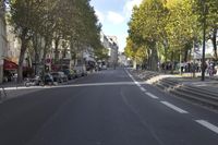 a empty street in a european city with no cars on it and lots of motorcycles parked