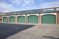 a photo of garages and cars in a warehouse area on a sunny day with some clouds in the sky