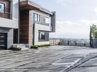 the exterior and landscape of a modern house in los angeles, california with stone and wood