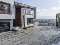 the exterior and landscape of a modern house in los angeles, california with stone and wood