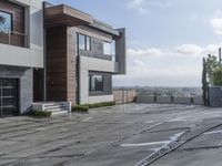 the exterior and landscape of a modern house in los angeles, california with stone and wood