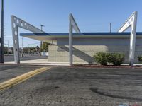 an empty city street with a concrete building and a blue canopy over it and an outside area