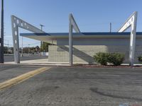 an empty city street with a concrete building and a blue canopy over it and an outside area