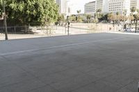 a woman is skateboarding in an outdoor courtyard area near buildings and trees, there are also people around