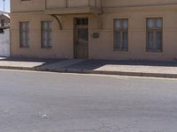 a building with the sign that reads to the right of the road is a closed street, with a yellow line on the road in front of it, and some buildings