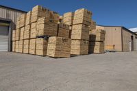 a number of stacks of hay stacked next to each other in a warehouse with a sky background