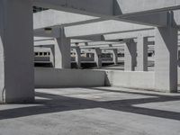 several buildings with concrete roof and flooring in an empty parking lot area on a sunny day