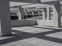 several buildings with concrete roof and flooring in an empty parking lot area on a sunny day