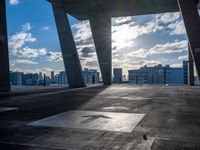 a street view of several huge structures and sky in the background with sun peaking through